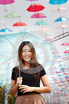 Smiling Asian girl with umbrellas