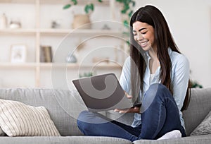 Smiling Asian Girl Working Remotely On Laptop At Home, Sitting On Couch