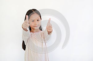 Smiling Asian little child girl child pointing at you and looking camera isolated on blue background. Kid point two index fingers