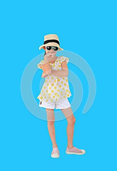 Smiling asian little girl wearing sunglasses and straw hat isolated on light blue background with clipping path. Summer and