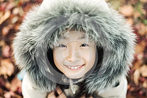 Smiling asian Little girl in a winter fur hat
