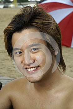 Smiling asian man at beach