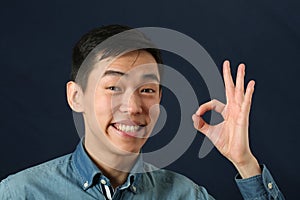 Smiling Asian man giving okay sign