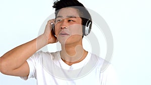 Smiling Asian man listening to music with headphones