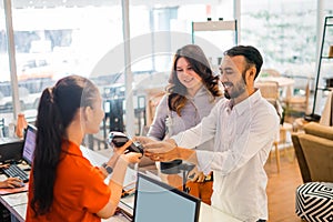 smiling Asian man using EDC device while buying and making payment