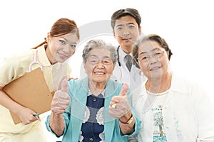 Smiling Asian medical staff with old women