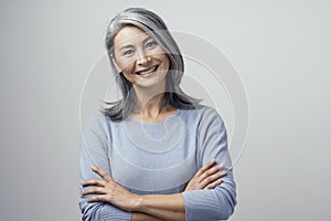 Smiling Asian senior woman with crossed arms