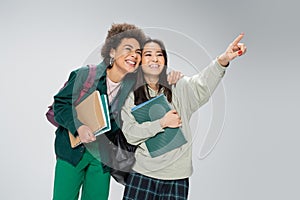 smiling asian student with copybooks looking