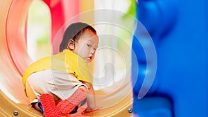 Smiling Asian Toddler Baby Boy happily playing on the playground, radiating joy and childhood fun.