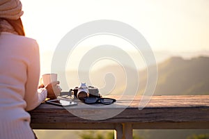 Smiling asian Woman drinking coffee and tea and take a photo and relax in sun sitting outdoor in sunshine light enjoying her warm photo