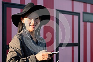 smiling asian woman with earphones listening music