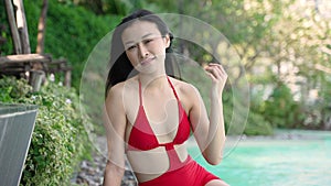 Smiling Asian Woman Enjoying a Luxurious Vacation by the Pool