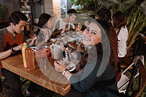 Smiling asian woman enjoying their garden dinner party