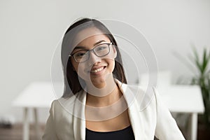 Smiling asian woman in glasses looking at camera, headshot portr