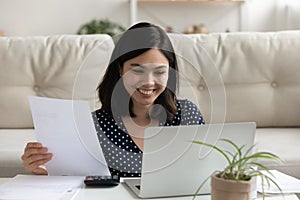 Smiling asian woman pay bills using easy banking on laptop