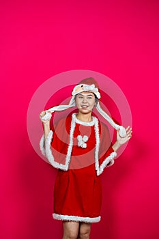 Smiling Asian Woman Posing on an Isolated Red Background With Christmas Attire photo