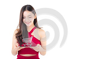 Smiling asian woman in red dress holding tablet with glad girl and cart on tablet.