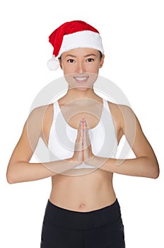 Smiling asian woman in Santa`s hat engaged in fitness