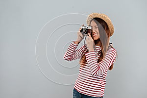 Smiling asian woman in sweater and hat making photo