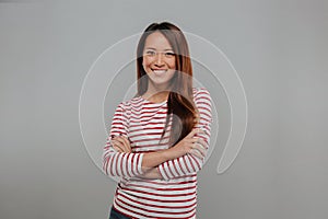 Smiling asian woman in sweater posing with crossed arms