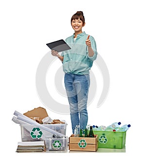 smiling asian woman with tablet pc sorting waste