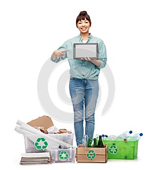 smiling asian woman with tablet pc sorting waste