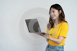 Smiling asian woman working on laptop computer isolated on white background