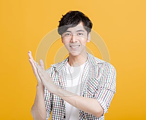 Smiling asian young man Clapping and applauding