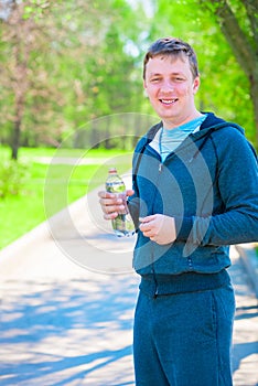 Smiling athlete with bottle of water