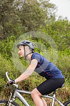 Smiling athletic blonde mountain biking