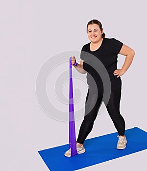 Smiling athletic large woman training body at home, active sports workout. Fat female athlete in activewear doing