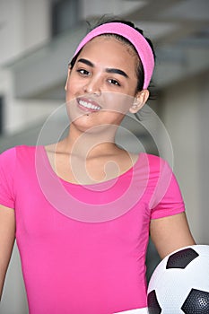 Smiling Athletic Minority Female Soccer Player With Soccer Ball