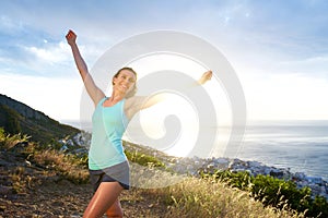 Smiling athletic woman with arms outstretched