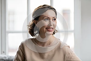 Smiling attractive elderly woman enjoying dreamy relaxed calm moment.