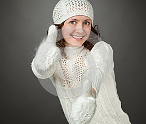 Smiling attractive girl showing thumbs up in mittens