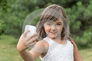 Smiling attractive little girl is doing selfie