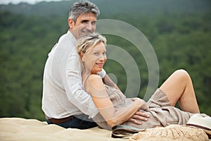 smiling attractive middle-aged couple relaxing at beach