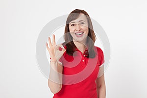 Smiling attractive middle aged woman showing thumbs up, okay. Isolated. Copy space