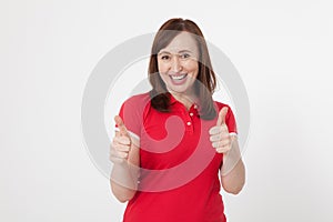 Smiling attractive middle aged woman showing thumbs up, okay on white background. Copy space