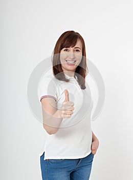 Smiling attractive middle aged woman showing thumbs up, okay on white background. Copy space.