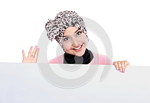 Smiling attractive muslim woman holding blank white board