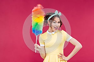 Smiling attractive pinup girl holding colorful duster brush