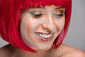 smiling attractive woman with red hair and glitter on face