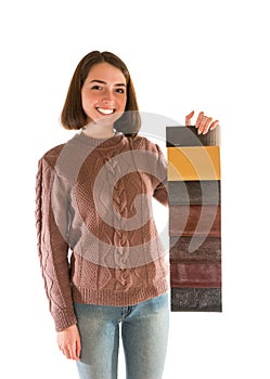 Smiling attractive woman in sweater holding fabric swatches