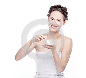 Smiling, attractive woman using a moisturizer.