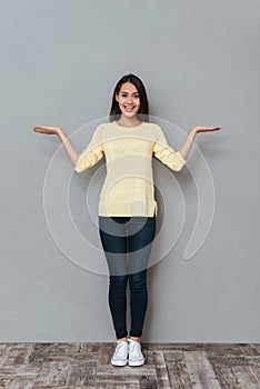 Smiling attractive young woman holding copyspace on both palms