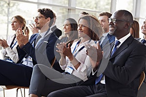 Smiling audience applauding at a business seminar