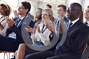 Smiling audience applauding at a business seminar