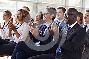 Smiling audience applauding at a business seminar