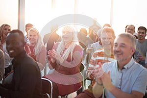 Smiling audience applauding at a business seminar